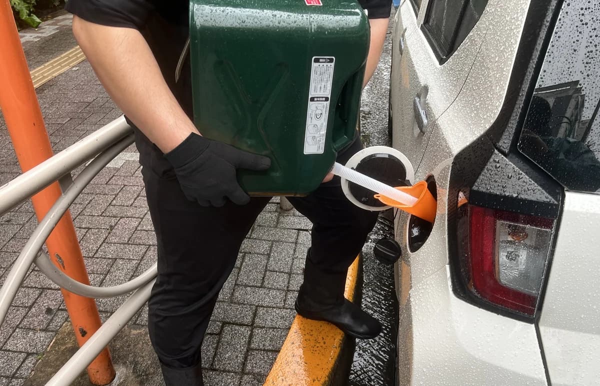 隊員が携行缶から漏斗を使って車両へ給油する様子